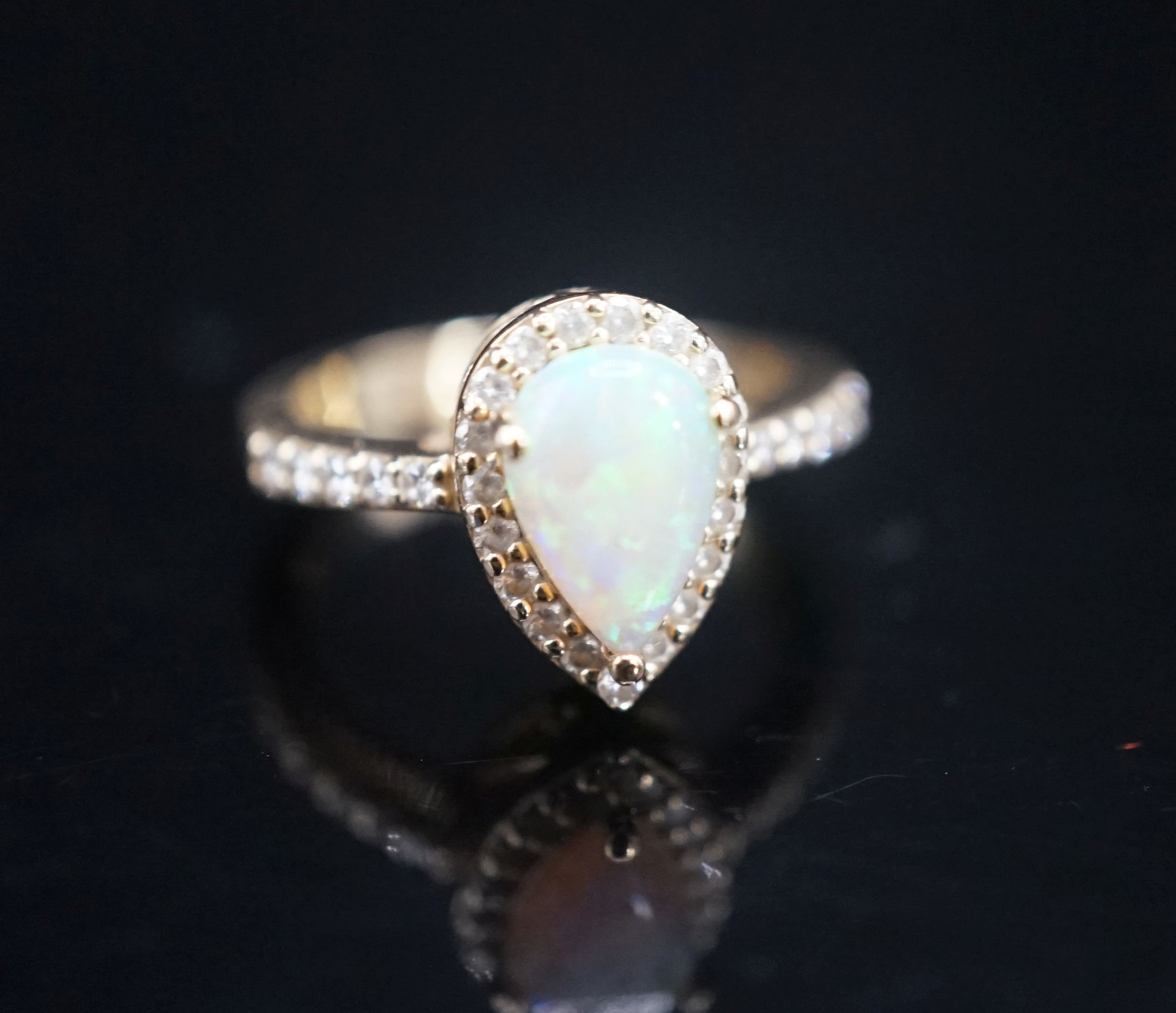 A modern 14k yellow meta, white opal and diamond set pear shape cluster ring, with diamond set shoulders, size K, gross weight 4.3 grams.